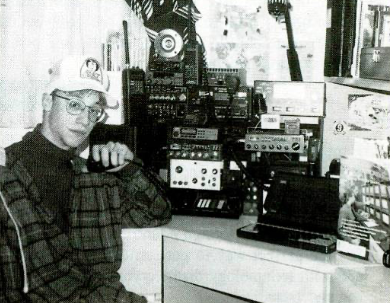 Caption: Nerdy-ass, late-teenybopper me, in my old ham shack, circa 1993. Somehow, I still got lots of hot chicks. The photo was featured in the July 1994 issue of Popular Communications magazine. On the desk, is my old Tandy 3800HD laptop, running SLS Linux (and later Slackware Linux…fortunately).